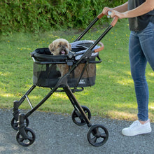 a woman pushing a silver pearl design dog stroller in the park
