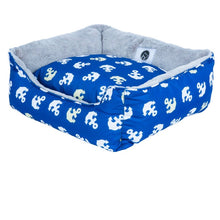 a small blue dog bed with anchor prints 