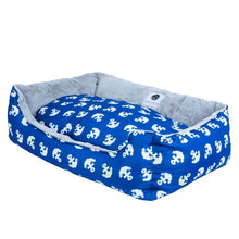 a close up image of a blue dog bed with anchor prints