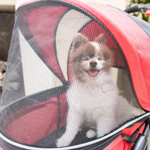 a close up image of a happy dog inside a red stroller with net covers 