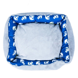 top view image of a blue dog bed with anchor prints 