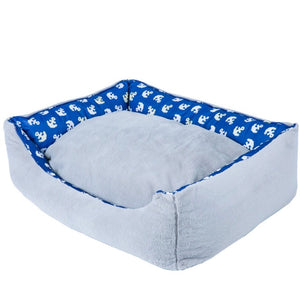 full view image of a reversed side of a blue dog bed with anchor prints 