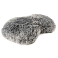 a close up image of a grey furry dog bed with white background
