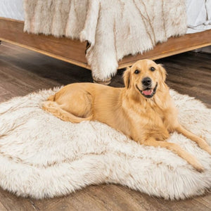 a golden retriever laying on a curved white dog bed on a wooden floor next to a wooden bed in a bedroom