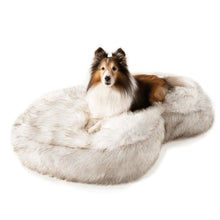 a dog laying on a white fluffy dog bed