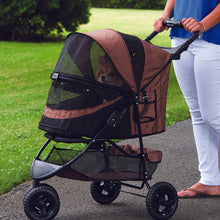 a woman walking her dog in a chocolate colored dog stroller in the park