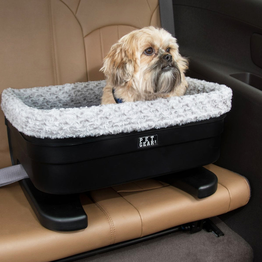 close up image of a shih-tzu inside a black dog bucket with fog insert in a leather car seat