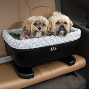 close up image of two shih-tzu inside a black dog bucket with fog insert in a leather car seat\
