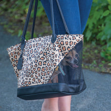 A close up image of a dog inside a jaguar printed Rest & Relax Tote Bag being carried by a lady