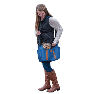 a lady wearing black vest and white sweatshirt carrying her dog  on a navy blue Sling Pet Carrier Purse