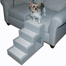 a yorkie standing on a grey couch next to a four step pet stair with pet den