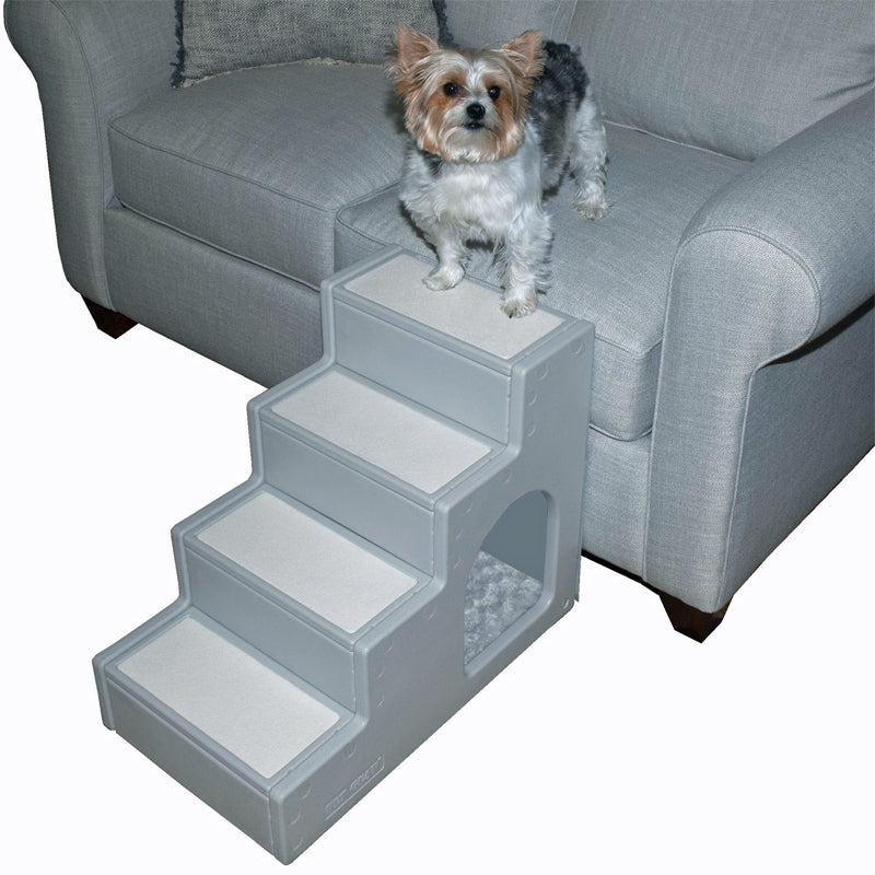 a yorkie standing on a grey couch next to a four step pet stair with pet den