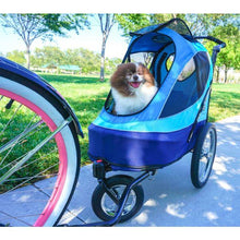 A Baby-Blue colored Pet Stroller with a happy dog inside it attached to a bicycle